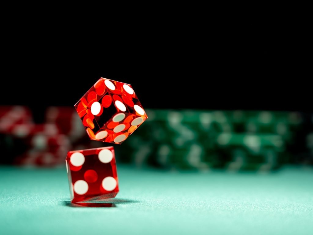 Red dice rolling on green Craps table at Wild Diamonds Fun Casino event with poker chips in background