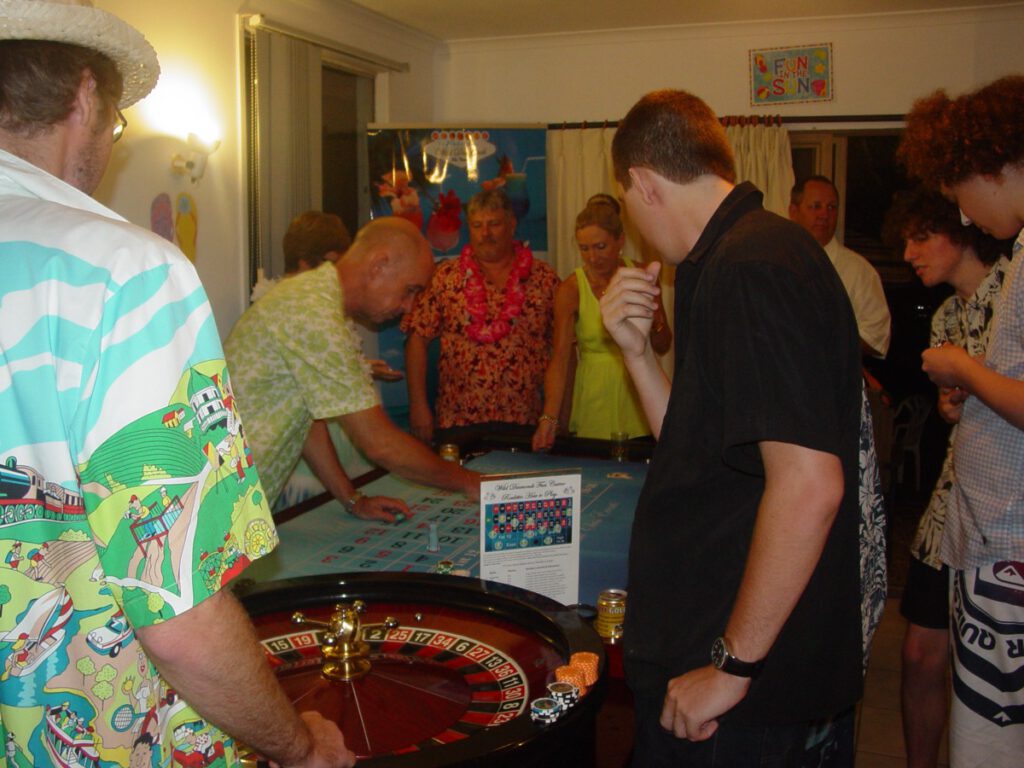 Tropical roulette gaming at Wild Diamonds Fun Casino Brisbane event - Guests in Hawaiian attire enjoying casino entertainment for Sunshine Coast and Brisbane themed parties