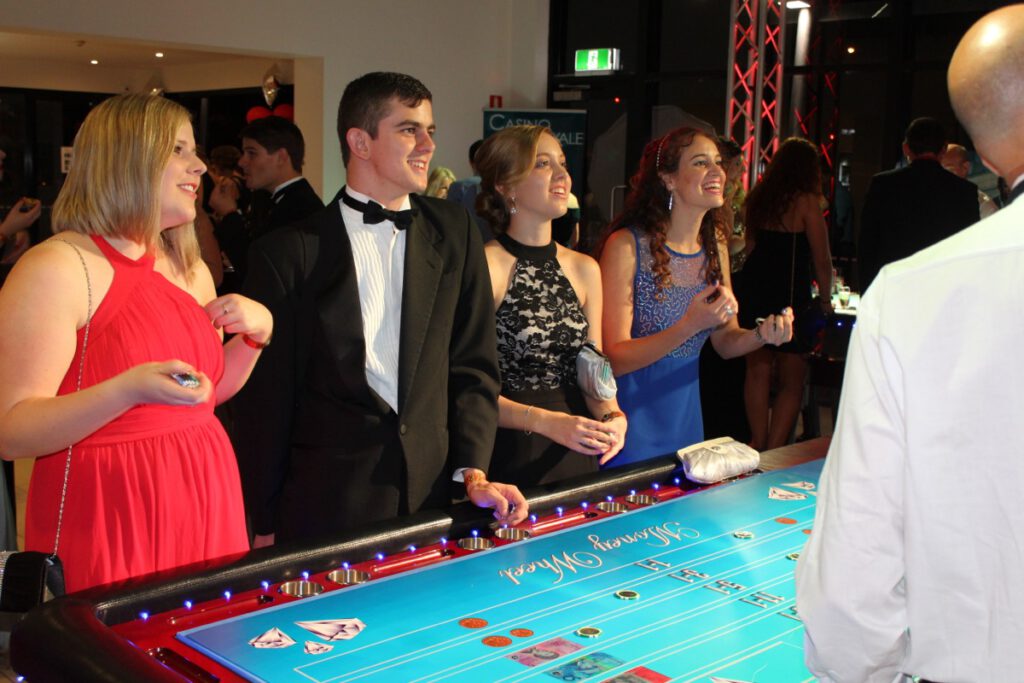 Young professionals enjoying casino gaming at Wild Diamonds Fun Casino Brisbane event - Engaged guests at casino table for Sunshine Coast and Brisbane parties