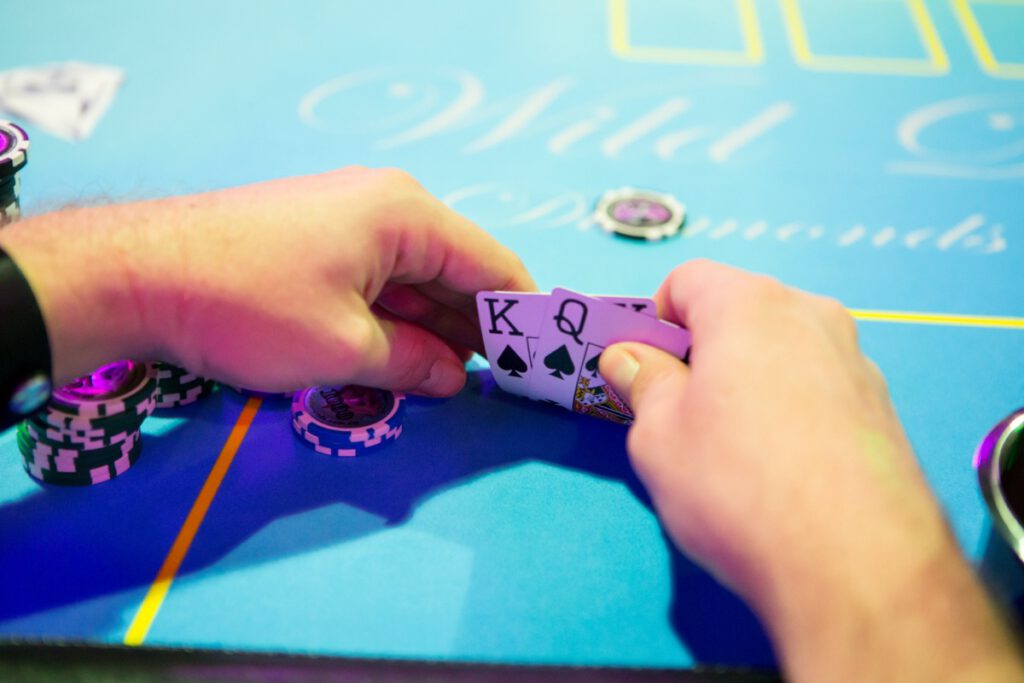 Poker player's hand at Wild Diamonds Fun Casino Brisbane event - Close-up poker gaming for Sunshine Coast and Brisbane parties
