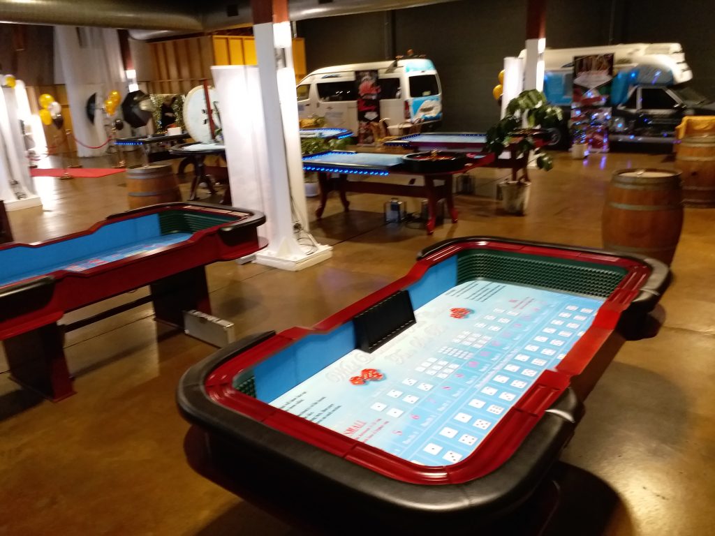 Complete mobile casino event setup by Wild Diamonds Fun Casino Brisbane - Professional craps and roulette tables with festive decorations for outdoor and indoor Sunshine Coast and Brisbane events
